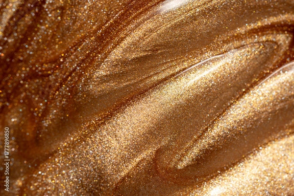 Fototapeta Glowing golden shimmering cosmetic texture of gel or body spray. Background texture for backdrops or mapping.