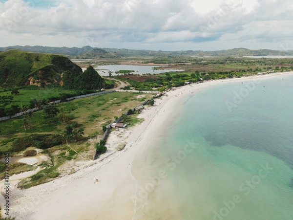 Fototapeta The coastal view is surrounded by enchanting green hills, including Merese Hill, which offers a spectacular viewpoint to enjoy the scenery. LOMBOK, NTB , INDONESIA