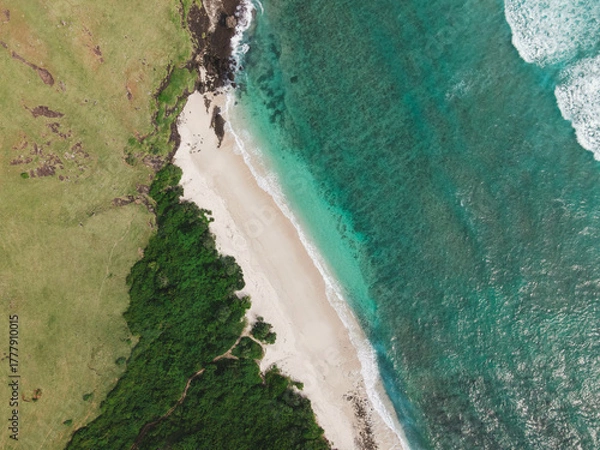 Fototapeta The coastal view is surrounded by enchanting green hills, including Merese Hill, which offers a spectacular viewpoint to enjoy the scenery. LOMBOK, NTB , INDONESIA