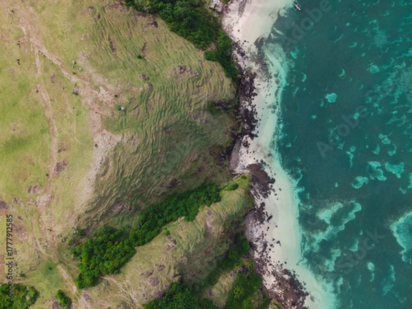Fototapeta The coastal view is surrounded by enchanting green hills, including Merese Hill, which offers a spectacular viewpoint to enjoy the scenery. LOMBOK, NTB , INDONESIA