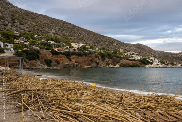 Fototapeta A sandy beach on an island in Greece is filled with a variety of debris brought by the waves of the sea. The concept of marine pollution, pollution of ocean water by plastic, garbage and human waste.