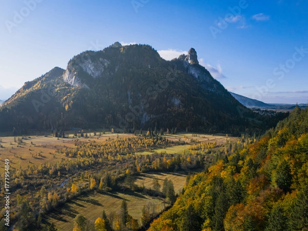 Obraz Ettaler Weidmoos autumn aerial with the Ammer River, Kofel and Rappenkopf under clear blue sky; warm valley tones, tranquil mood, ideal for travel ads.