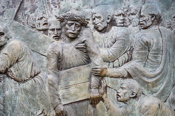 Obraz Station V: Simon of Cyrene helps Jesus carry the Cross. The Way of the Cross on Mount Križevac (the Cross Mountain) in Medjugorje.