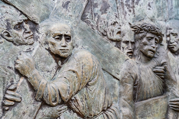 Obraz Station V: Simon of Cyrene helps Jesus carry the Cross. The Way of the Cross on Mount Križevac (the Cross Mountain) in Medjugorje.