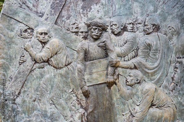 Obraz Station V: Simon of Cyrene helps Jesus carry the Cross. The Way of the Cross on Mount Križevac (the Cross Mountain) in Medjugorje.