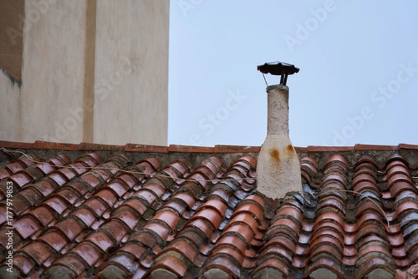 Fototapeta Ventilation pipe on an old tiled roof.