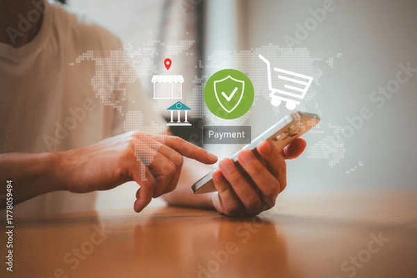 Fototapeta man holding smart phone paying online using digital wallet credit card, man using smartphone mobile to make a payment online sitting in home office