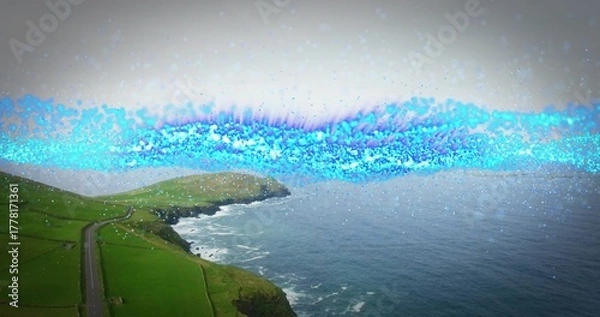 Fototapeta Winding narrow paved road hugging grassy cliffside at cliff edge, with blue light band, copy space