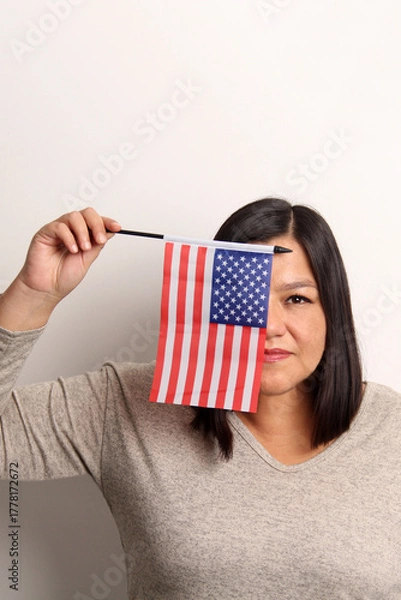 Fototapeta 40-year-old Latina woman proudly displays the United States flag as a symbol of migration and freedom