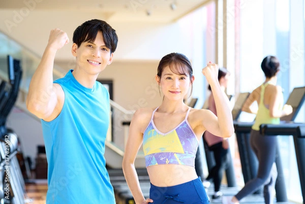Obraz ジムでガッツポーズする若い男女　インストラクター　撮影協力：スポーツクラブ&サウナスパ ルネサンス 幕張24