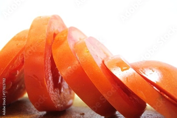 Obraz Fresh red tomato slices, solanum lycopersicum or lycopersicum esculentum on an old wooden cutting board photographed on the isolated white background