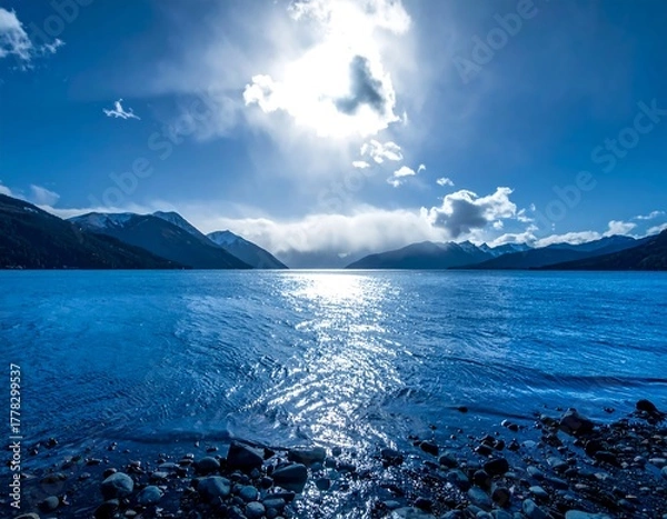 Fototapeta Vast lake with mountains and bright sky