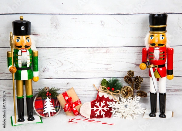 Obraz Christmas  background with decorations, candy canes, snowflakes, bear toy  and gift box on snow and white wooden board 