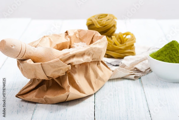 Fototapeta uncooked taglatelle pasta and ingredients: grounded spinach powder and whole wheat flour