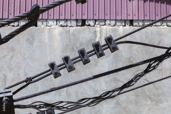 Fototapeta Wire with five metal clips hanging from it