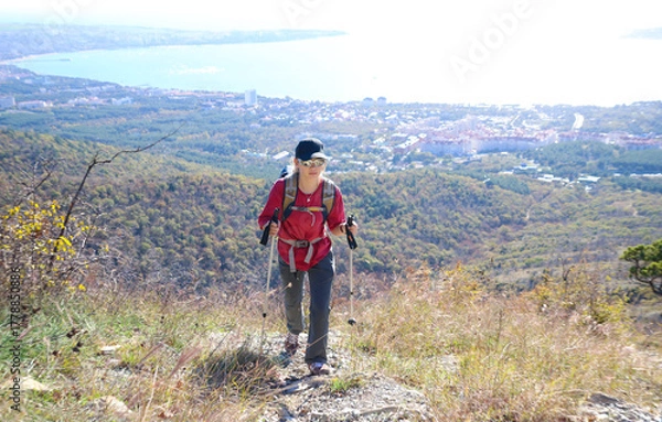 Obraz young girl with a backpack is hiking alone in nature