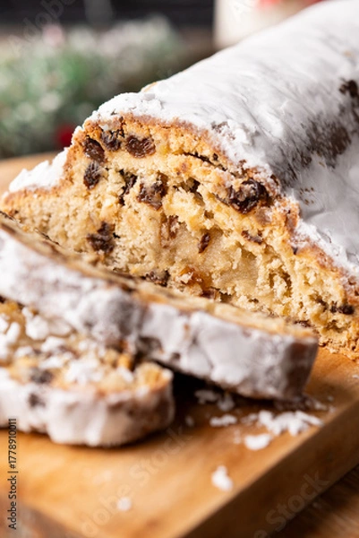 Obraz Traditional Christmas Stollen with Raisins and Powdered Sugar on wooden table