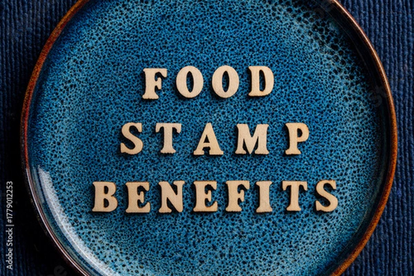 Fototapeta The inscription on the blue plate about food stamp benefits, closeup. The Supplemental Nutrition Assistance Program, known as the Food Stamp Program, is a United States federal government program
