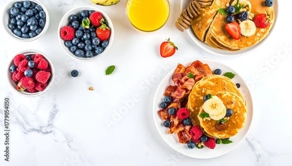 Fototapeta Overhead view of a breakfast spread with pancakes, berries, and bacon.
