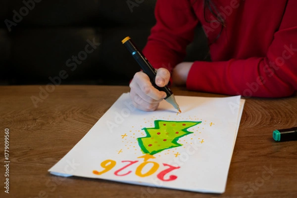 Obraz A girl draws a Christmas tree with a marker