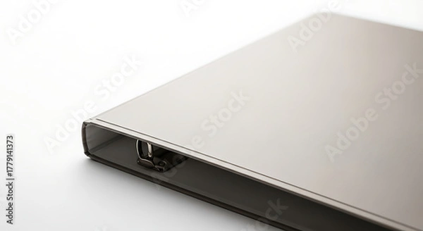Fototapeta A close up shot of a silver binder with metal rings on a white surface in a studio setting ai generated