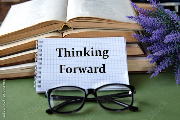 Fototapeta Notebook with THINKING FORWARD text on a green background with books and glasses