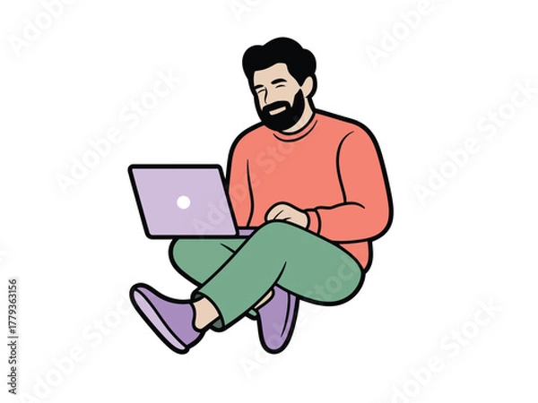 Fototapeta A man with a beard sits cross-legged on the floor using a laptop computer.