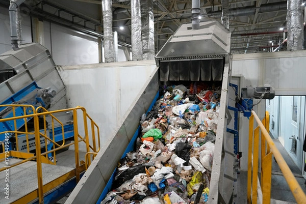 Obraz A conveyor belt with waste at a plant, waste moves along the belt to be sorted into fractions and collected for further processing.
