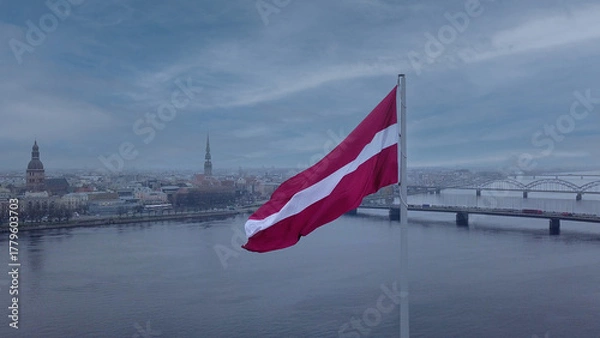Fototapeta Drone View Of Riga Old Town With Latvian Flag Waving In Foreground Aerial Panorama Of Historic City Center, Daugava River And Urban Skyline On A Outumn Day In Latvia