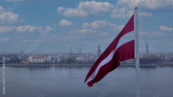Fototapeta Drone View Of Riga Old Town With Latvian Flag Waving In Foreground Aerial Panorama Of Historic City Center, Daugava River And Urban Skyline On A Outumn Day In Latvia