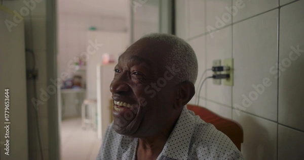Fototapeta Elderly man of African descent laughing joyfully in tiled kitchen, expressing happiness and connection, candid everyday moment in a warm home setting