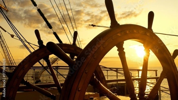 Fototapeta at sea at sunset at the old ship's wheel