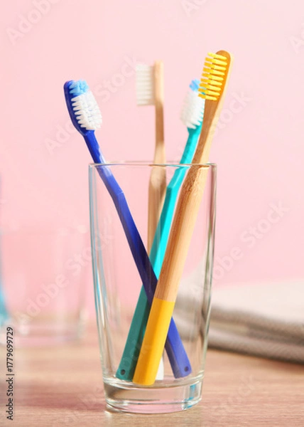 Fototapeta Natural bamboo and plastic toothbrushes on the table.. Vertical photo format