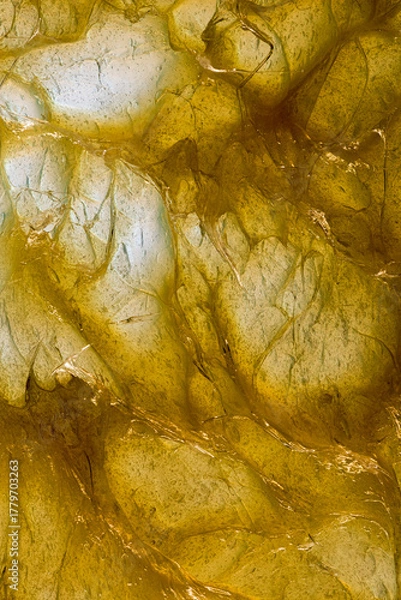 Fototapeta Abstract texture of yellow bearing grease illuminated from below, forming organic shapes, reflections, and patterns resembling the fluid energy of mechanics