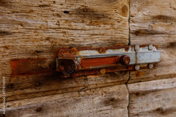Fototapeta Rustic wooden door with weathered metal bolt close-up