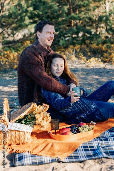 Fototapeta Portrait happy beautiful couple in love enjoying autumn picnic in autumn park. Vertical photo. High quality photo