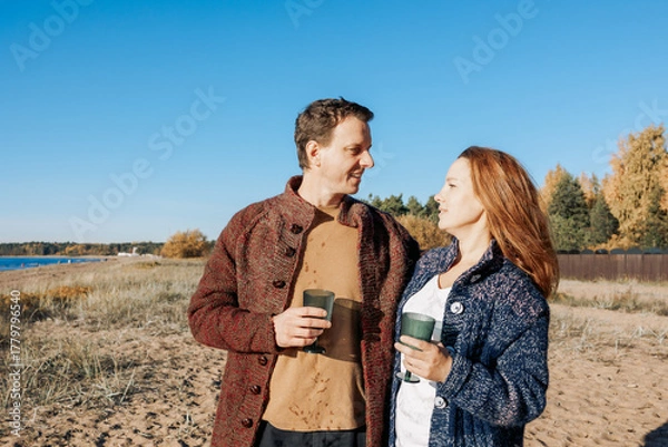 Obraz Happy beautiful couple in love enjoying autumn picnic on coast in open air. Weekend and lifestyle concept. High quality photo