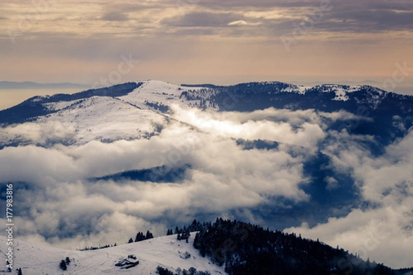 Fototapeta Spectacular clouds formation in the Schneidenbach valley. Taken from the Hohneck on a beautiful cold winter day with a lot of snow.