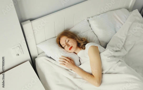 Fototapeta Woman sleeping lying in bed on white soft comfortable pillow in bedroom at home