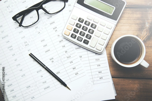 Fototapeta cup of coffee and calculator on document