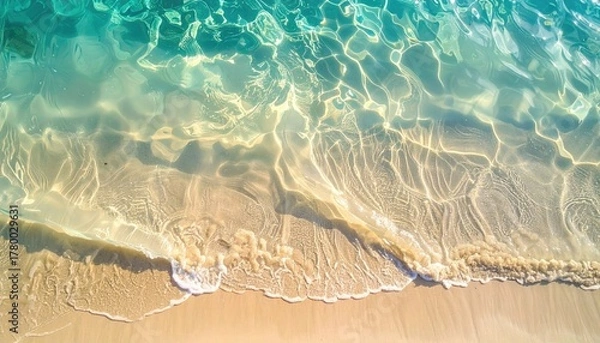 Fototapeta Gentle Ocean Waves Lap on a Sandy Shoreline Under Soft Golden Sunset Light Creating Rippling Reflections on Clear Turquoise Water