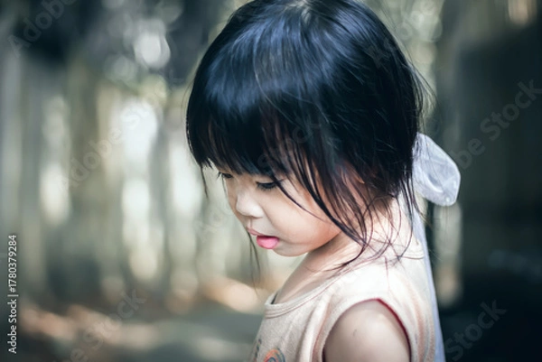 Fototapeta Portrait of a beautiful little asian girl in the park.