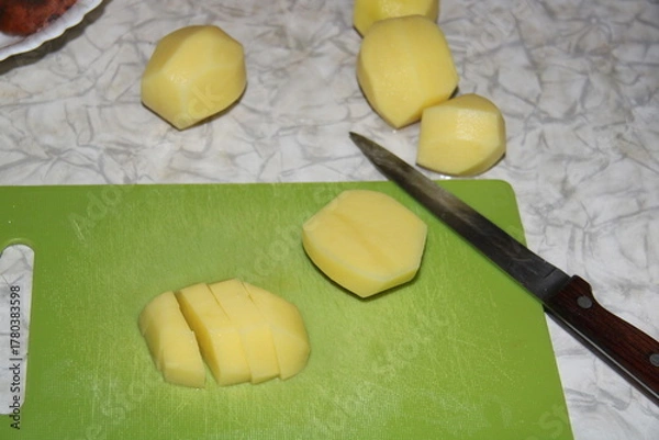 Fototapeta sliced potatoes on a green board