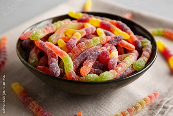 Fototapeta Sugary Sour Gummy Worms in a Bowl, side view.
