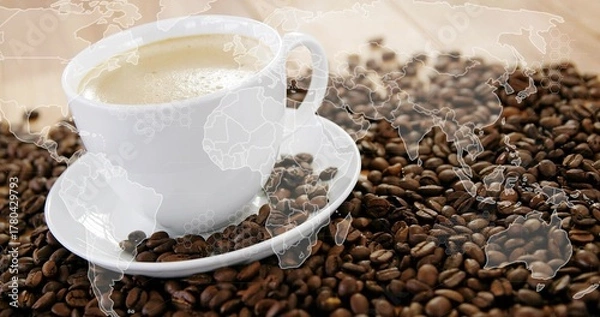 Obraz White ceramic cup with saucer holding frothy coffee on beans strewn tabletop, world map overlay