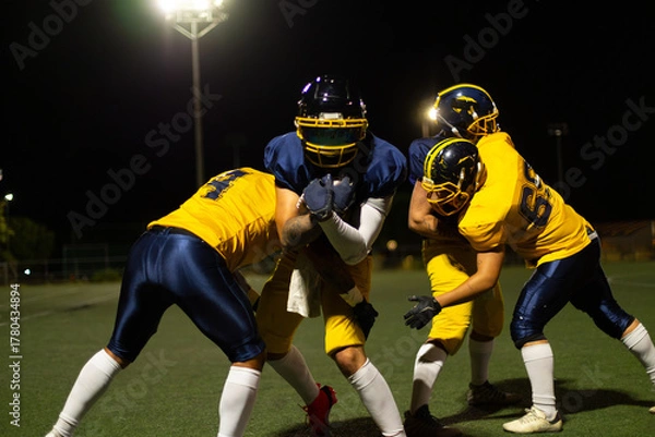 Obraz American football players tackling during night game