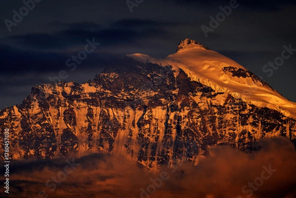 Obraz Alp Sunset. Foggy morning in Swiss Alps, early morning in the mountain during violet pink twilight, hills in the clouds. End of the night.