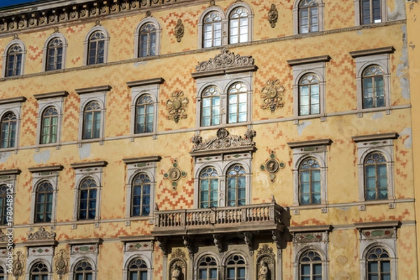 Fototapeta ornate historic building facade with arched windows and balcony