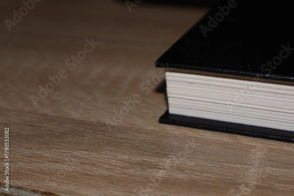 Obraz Close-up hardcover book on wooden table, pages and cover detail in shallow depth of field for reading, study and knowledge concept
