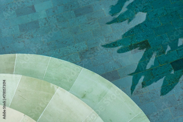 Fototapeta Abstract overhead view swimming pool steps stair turquoise water clear shadow tree leaf. Tropical vacation resort relaxation copy text space background